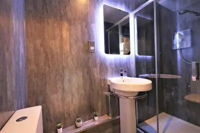 a bathroom with a sink and a toilet and a shower at Signature - Linden House Flat 1 in Airdrie