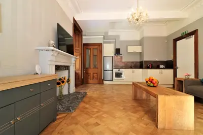 a kitchen and living room with a table and a fireplace at Signature - Linden House Flat 1 in Airdrie