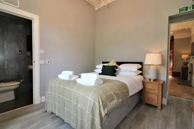 a bedroom with a bed and a bathroom with a tub at Signature - Linden House Flat 1 in Airdrie