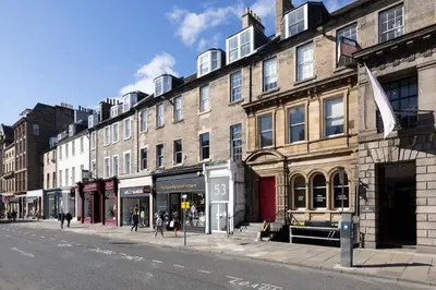 a street with buildings and people walking on the street at JOIVY Inviting Flat at the Heart of Edinburgh in Edinburgh