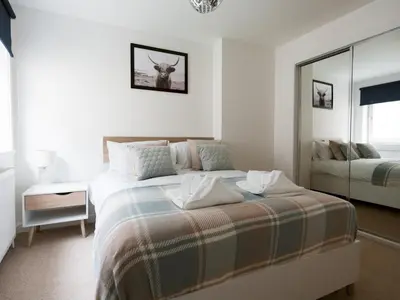 a white bedroom with a bed and a mirror at Beautiful Unique 3Bed Mews Cottage House - Pass the Keys in Glasgow