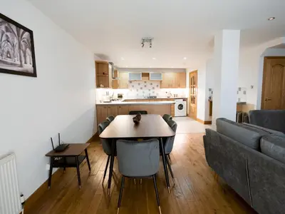a kitchen and living room with a table and a couch at Beautiful Unique 3Bed Mews Cottage House - Pass the Keys in Glasgow