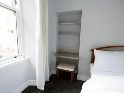 a bedroom with a bed and a chair next to a window at Superb 1Bed Flat in Fabulous West End - Pass the Keys in Glasgow