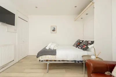 a white bedroom with a bed and a couch at Central Studio Near Usher Hall & Edinburgh Castle in Edinburgh