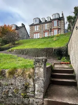 an old house on a hill with stairs in front at Dairsie Sea View in Rothesay