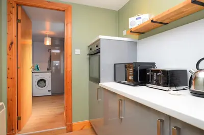 a kitchen with a counter top with a microwave at Chapelton Cottage in Strachur