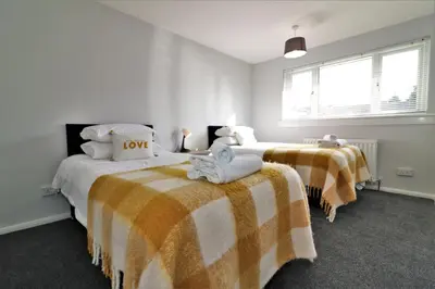 a bedroom with two beds with towels on them at Signature - Morland House in East Kilbride