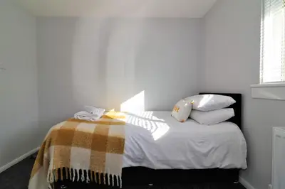 a bedroom with a bed with a blanket and pillows at Signature - Morland House in East Kilbride