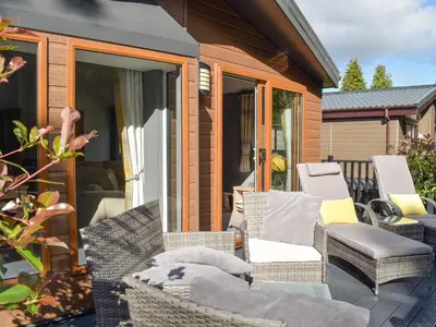 a patio with wicker chairs and a house at Devin Lodge in Dollar
