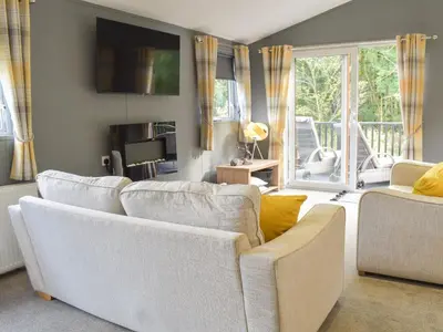 a living room with two white couches and a television at Devin Lodge in Dollar