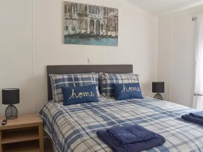 a bedroom with a bed with blue pillows and a painting at Devin Lodge in Dollar