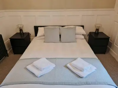 a bedroom with a bed with two towels on it at Superb Loch Side Apartment with Sea & Sunset Views in Helensburgh
