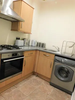 a kitchen with a stove and a washing machine at Beautiful & spacious 2 bed apt in Glasgow West End in Glasgow