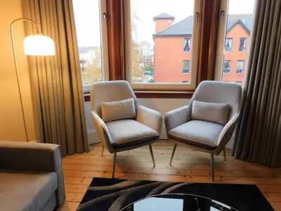 two chairs in a living room with two windows at Beautiful & spacious 2 bed apt in Glasgow West End in Glasgow