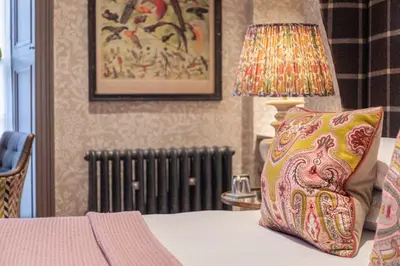 a bedroom with a bed with a pillow and a lamp at The Raeburn in Edinburgh