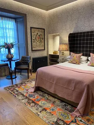a bedroom with a bed and a chair and a rug at The Raeburn in Edinburgh