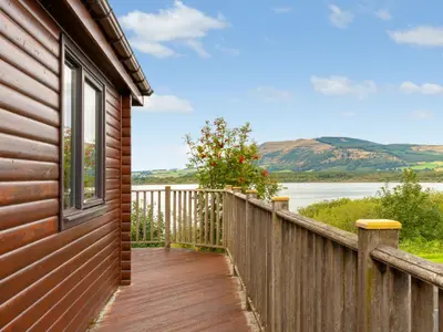 a wooden balcony with a view of the water at Chalet Lodge 9 by Interhome in Kinross