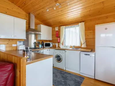 a kitchen with white appliances and a wooden ceiling at Chalet Lodge 9 by Interhome in Kinross