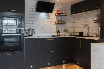 a kitchen with black cabinets and black appliances at The West End Loft - 5* Retreat - Private Parking! in Glasgow