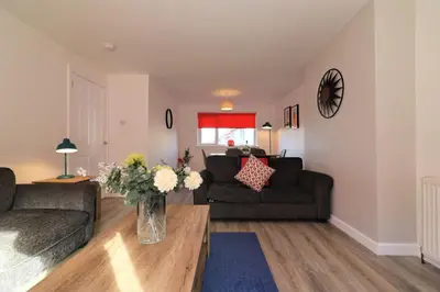 a living room with two couches and a table at Signature - Sydney House in East Kilbride
