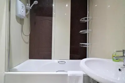 a bathroom with a shower and a sink and a tub at Signature - Kirkhill Middle in Kirkmuirhill