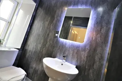 a bathroom with a sink and a mirror at Signature - Linden House Flat 4 in Airdrie