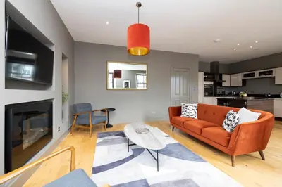 a living room with a couch and a table at JOIVY Stylish Flat in New Town in Edinburgh