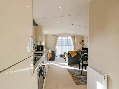 a kitchen with a stove top oven next to a living room at 11 Mansion View in Helensburgh