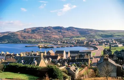a town on a lake with mountains in the background at Kennacraig Lodge in Whitehouse