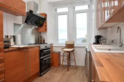 a kitchen with a sink and a stove top oven at Glen Oirig in Hunters Quay
