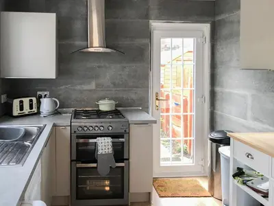 a kitchen with a stove and a sink at Kitty's Cottage in Girvan