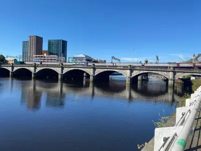 a bridge over a river with a city in the background at Lovely 1-Bed Apartment in Glasgow Merchant City in Glasgow