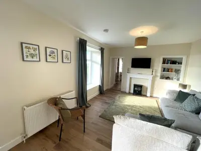 a living room with a couch and a fireplace at Beautiful 5BR Rural Cottage with Outstanding Views - Pass the Keys in Castle Douglas