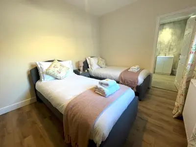 a room with two beds with towels on them at Beautiful 5BR Rural Cottage with Outstanding Views - Pass the Keys in Castle Douglas