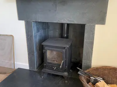 a black stove in a room with a fireplace at Beautiful 5BR Rural Cottage with Outstanding Views - Pass the Keys in Castle Douglas