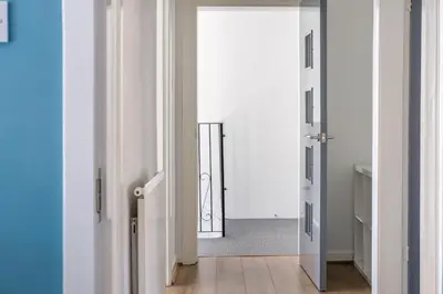 a hallway with white walls and an open door at The Douglas - Spacious 2 bed apartment in Uddingston in Uddingston