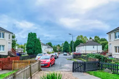 a street with cars parked in a residential neighbourhood at Millfield House - Cosy 2 bed house in Motherwell in Motherwell