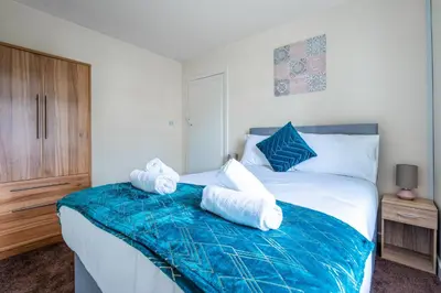 a bedroom with a bed with towels on it at Millfield House - Cosy 2 bed house in Motherwell in Motherwell