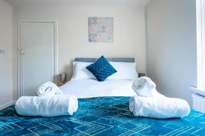 a bedroom with a bed with two stuffed animals on it at Millfield House - Cosy 2 bed house in Motherwell in Motherwell