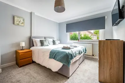 a bedroom with a bed and a window at Scotia House -3 bed house in Larkhall with private driveway in Larkhall