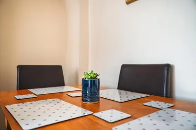 a wooden table with two chairs and a vase on it at Scotia House -3 bed house in Larkhall with private driveway in Larkhall