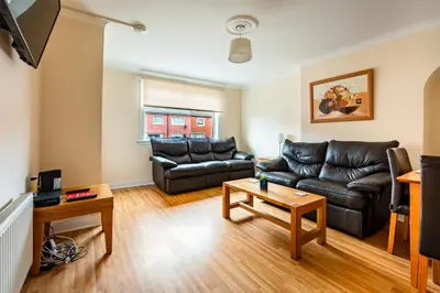 a living room with a couch and a table at Scotia House -3 bed house in Larkhall with private driveway in Larkhall