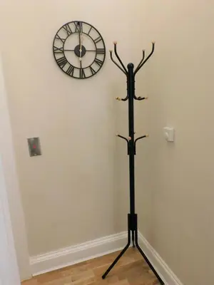 a clock on a wall next to a black pole at Beautiful 3 bed apt in the City Centre in Glasgow
