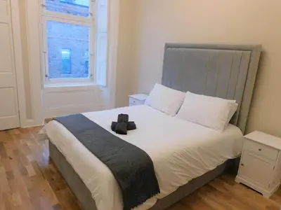 a bedroom with a bed with a teddy bear on it at Beautiful 3 bed apt in the City Centre in Glasgow