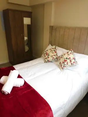 a white bed with two pillows and a towel on it at Fabulous 2 bed apt 10 mins from City Centre in Glasgow