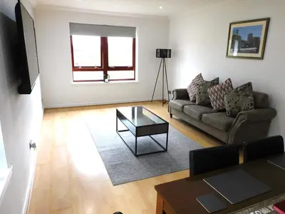 a living room with a couch and a table at Charming 2 bed apt close to City and SEC Hydro in Glasgow