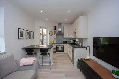 a living room with a couch and a kitchen at Bright Central Flat with Balcony and Free Parking in Glasgow
