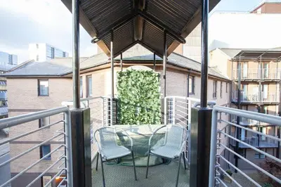 a patio with a table and chairs on a balcony at Bright Central Flat with Balcony and Free Parking in Glasgow