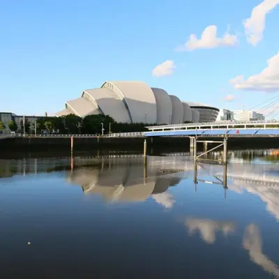 a bridge over a body of water in front of a building at Beautiful Flat with Panoramic Views over the City in Glasgow