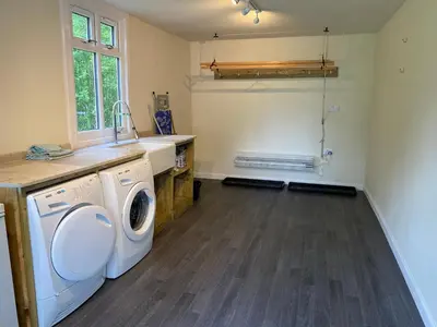 a laundry room with a washer and dryer at Riverside Cottage, Bridge of Balgie, Glenlyon, Perthshire in Bridge of Balgie